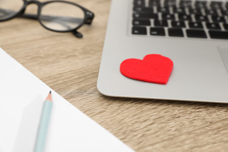 Red heart on laptop in office, closeup. Valentine's day celebrationの写真素材