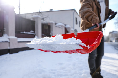 Person shoveling snow outdoors on winter day, closeupの写真素材