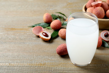 Lychee juice and fresh fruits on wooden table. Space for textの写真素材