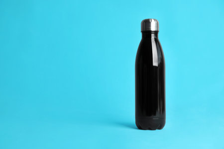 Stylish thermo bottle on light blue background, space for textの写真素材