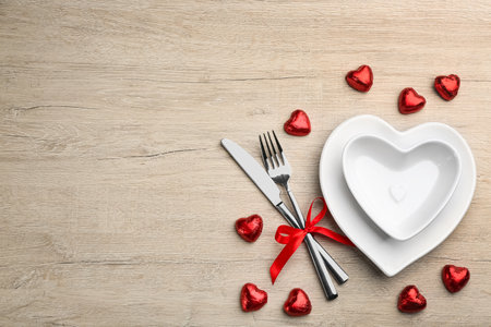 Beautiful table setting on white wooden background, flat lay with space for text. Valentine's Day dinnerの写真素材