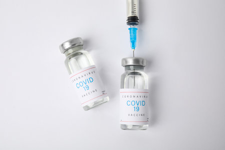 Filling syringe with coronavirus vaccine on white background, flat layの写真素材