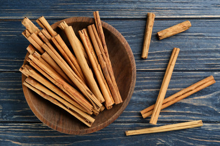 Aromatic cinnamon sticks on blue wooden table, flat layの写真素材