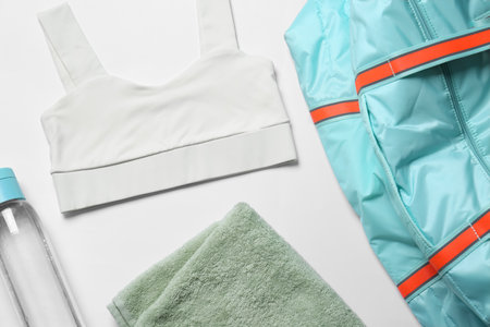 Gym bag, yoga sportswear, towel and bottle of water on white background, flat layの写真素材