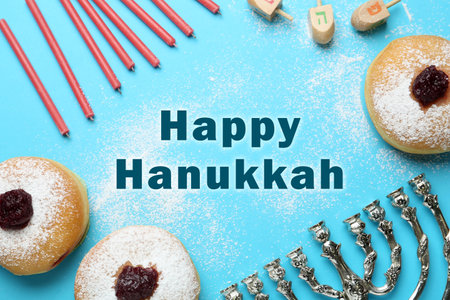 Happy Hanukkah. Traditional menorah, candles, sufganiyot and dreidels on light blue background, flat layの写真素材