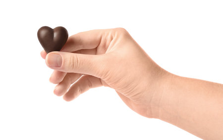 Woman holding heart shaped chocolate candy on white background, closeupの写真素材