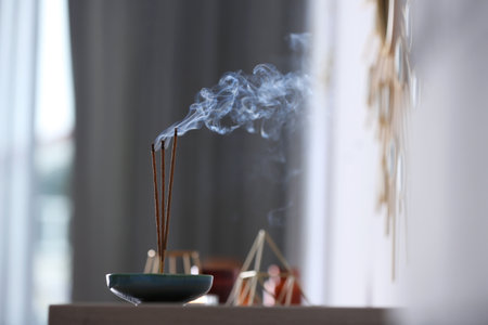 Incense sticks smoldering on table indoors, space for textの写真素材