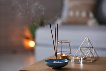 Incense sticks smoldering on table indoors, space for textの写真素材