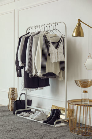 Rack with stylish clothes near white wall in dressing roomの写真素材