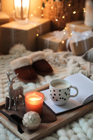 Wooden tray with cocoa, candle and notebook in room decorated for Christmasの写真素材
