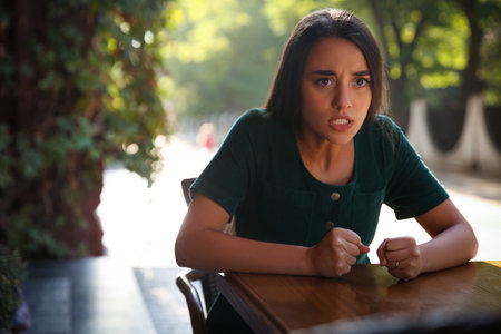 Jealous woman spying on ex boyfriend in outdoor cafeの写真素材