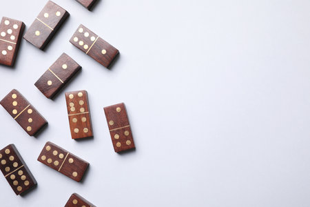 Wooden domino tiles on white background, flat lay. Space for textの写真素材