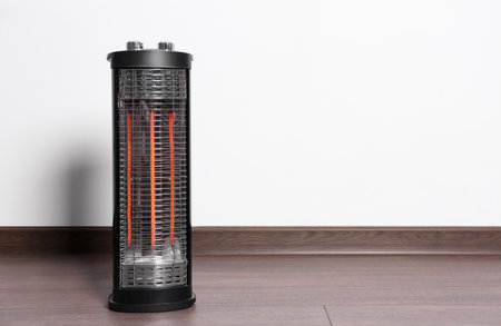 New modern electric heater on floor in room, space for textの写真素材