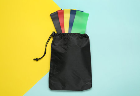 Bag with fitness elastic bands on color background, top viewの写真素材