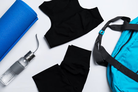 Yoga mat, stylish sportswear and bottle of water on white background, flat layの写真素材