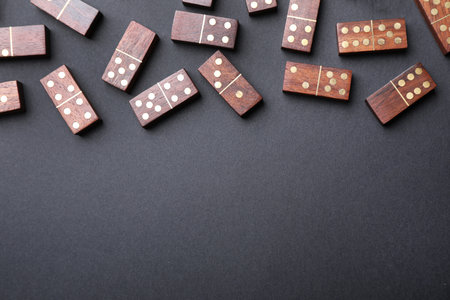 Wooden domino tiles on black background, flat lay. Space for textの写真素材