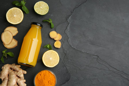 Flat lay composition with immunity boosting drink and ingredients on dark table. Space for textの写真素材