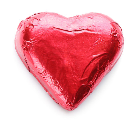 Heart shaped chocolate candy in red foil isolated on white, top viewの写真素材