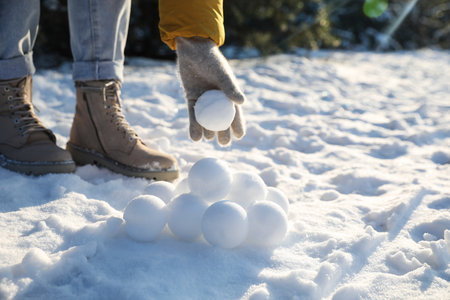 Woman rolling snowballs outdoors on winter day, closeupの写真素材