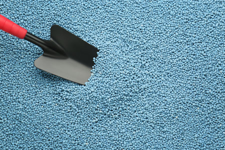 Shovel and granular mineral fertilizer, top view with space for textの写真素材