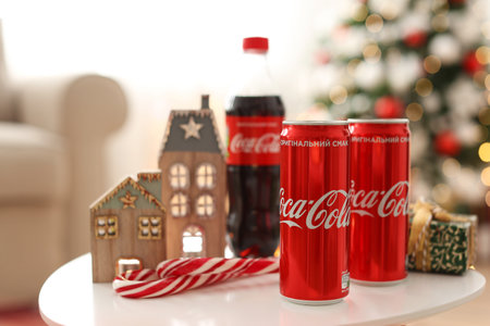 MYKOLAIV, UKRAINE - JANUARY 15, 2021: Coca-Cola cans and bottle near gift box on table with Christmas decorのeditorial素材