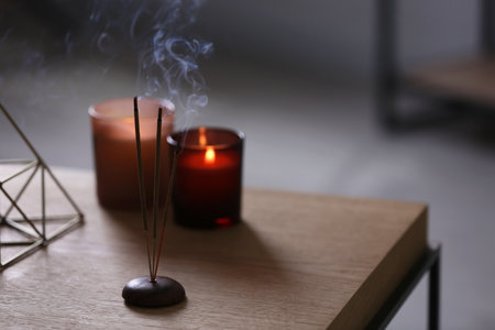 Incense sticks smoldering on table indoors, space for textの写真素材