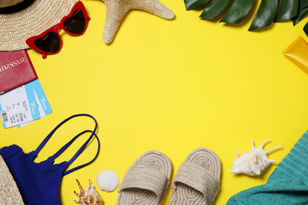Flat lay composition with beach accessories on yellow background. Space for textの写真素材