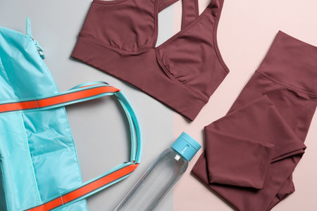 Gym bag, yoga sportswear and bottle of water on color background, flat layの写真素材