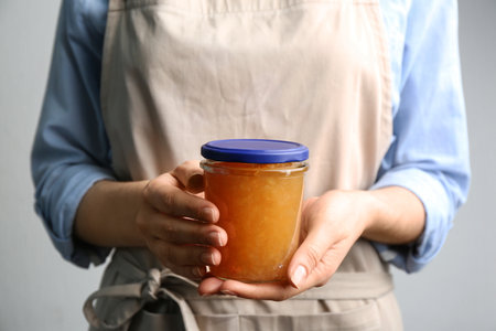 Woman with jar of delicious pear jam, closeupの写真素材