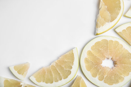 Slices of delicious ripe pomelo on white background, flat lay. Space for textの写真素材
