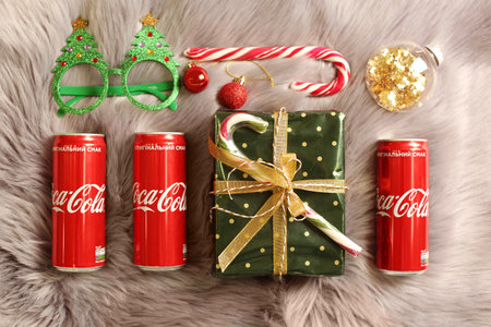 MYKOLAIV, UKRAINE - January 01, 2021: Flat lay composition with Coca-Cola cans and Christmas decorations on fur backgroundのeditorial素材