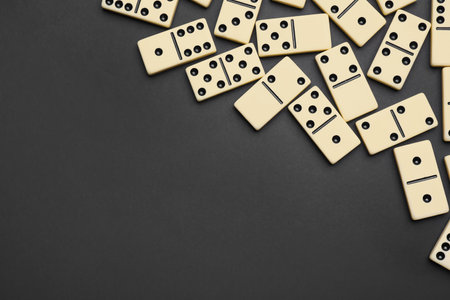 Classic domino tiles on black background, flat lay. Space for textの写真素材
