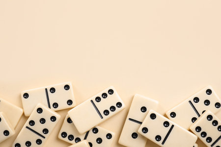 Classic domino tiles on beige background, flat lay. Space for textの写真素材