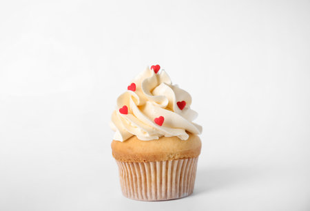 Tasty cupcake with heart shaped sprinkles for Valentine's Day on white backgroundの写真素材