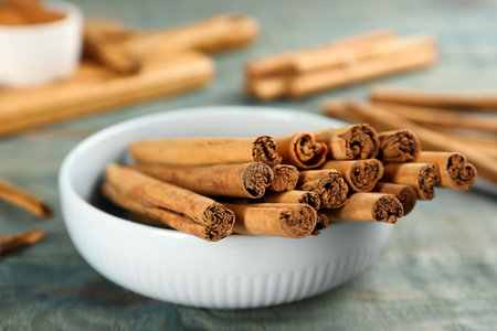 Aromatic cinnamon sticks on blue wooden table, closeupの写真素材