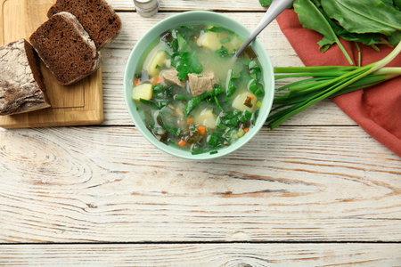 Delicious sorrel soup with meat served on wooden table, flat lay. Space for textの写真素材
