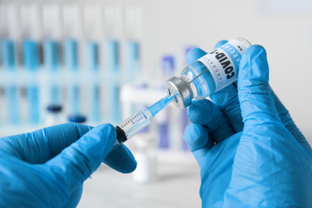 Doctor filling syringe with vaccine against Covid-19 indoors, closeupの写真素材