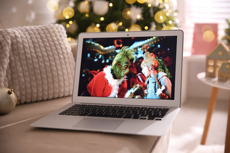 MYKOLAIV, UKRAINE - DECEMBER 25, 2020: Modern laptop displaying The Grinch movie indoors. Cozy winter holidays atmosphereのeditorial素材