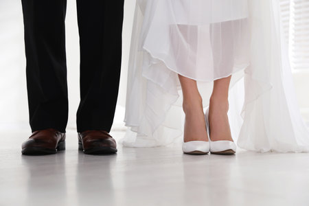 Bride and groom wearing elegant classic wedding shoes indoors, closeupの写真素材