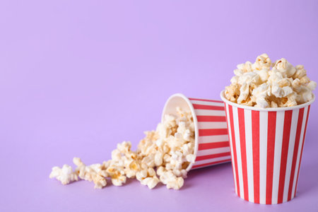 Delicious popcorn on lilac background. Space for textの写真素材
