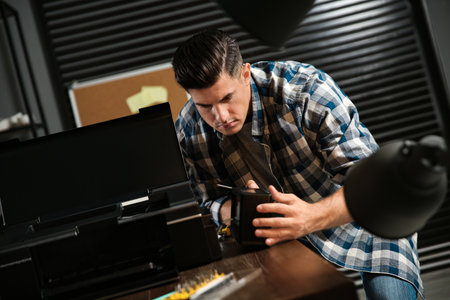 Professional repairman fixing modern printer in office