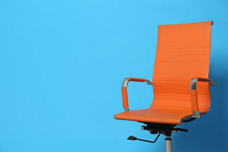 Comfortable office chair on light blue background, space for textの写真素材