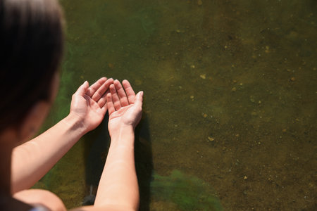 Woman taking pure water from river, closeup. nature healing powerの写真素材