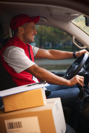 Courier in uniform on driver's seat of carの写真素材