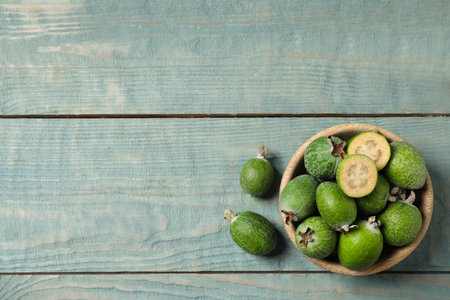 Flat lay composition with fresh green feijoa fruits on blue wooden table, space for textの写真素材