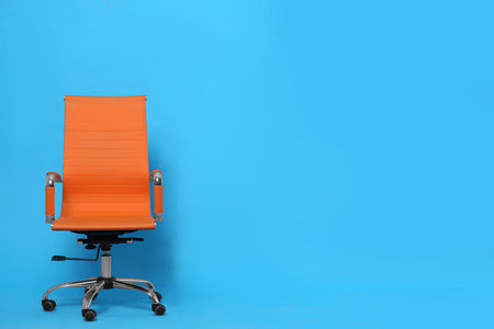 Comfortable office chair on light blue background, space for textの写真素材
