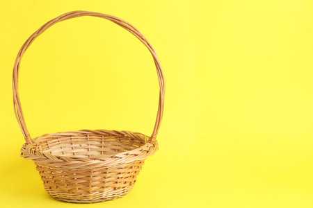 Empty wicker basket on color background, space for text. easter itemの写真素材