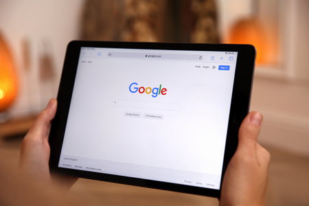 MYKOLAIV, UKRAINE - OCTOBER 31, 2020: Woman using Google search engine on tablet indoors, closeupのeditorial素材
