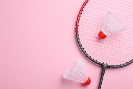 Badminton racket and shuttlecocks on pink background, flat lay. Space for textの写真素材