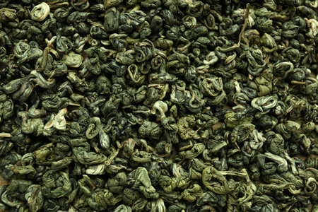 Dry green tea leaves as background, top viewの写真素材